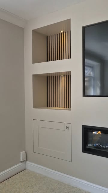 Media-wall composition with lit slatted niches, screen and inset fireplace.